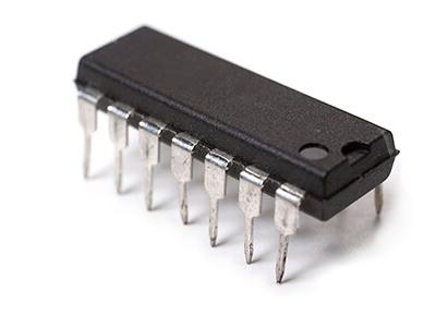 Close up of driver device for a circuit board, black with metal pins